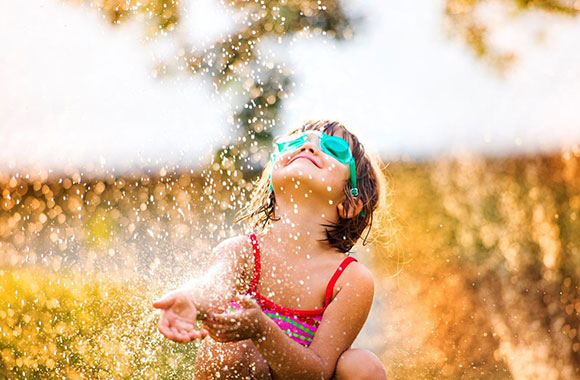 small child enjoying a sprinkler