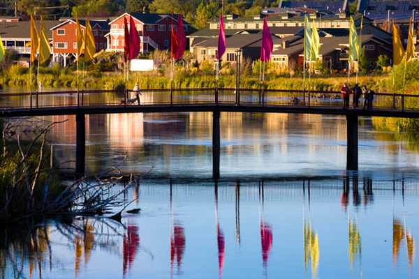 Footbridge over the Deschutes River in the Old Mill District. Multi-colored flags adorn the bridge.