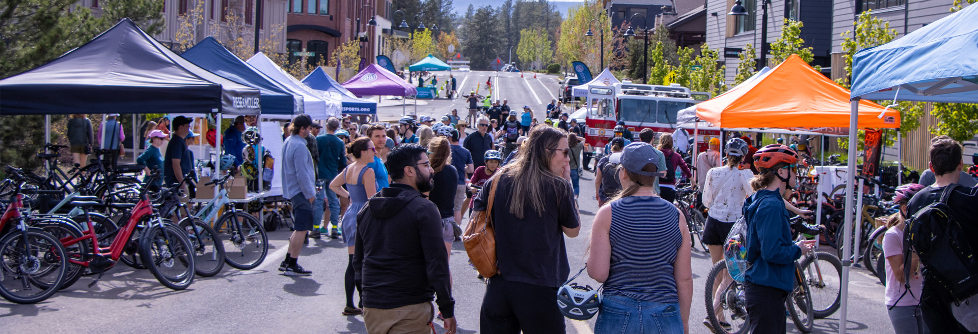 Street fair with vendors and people milling through booths.