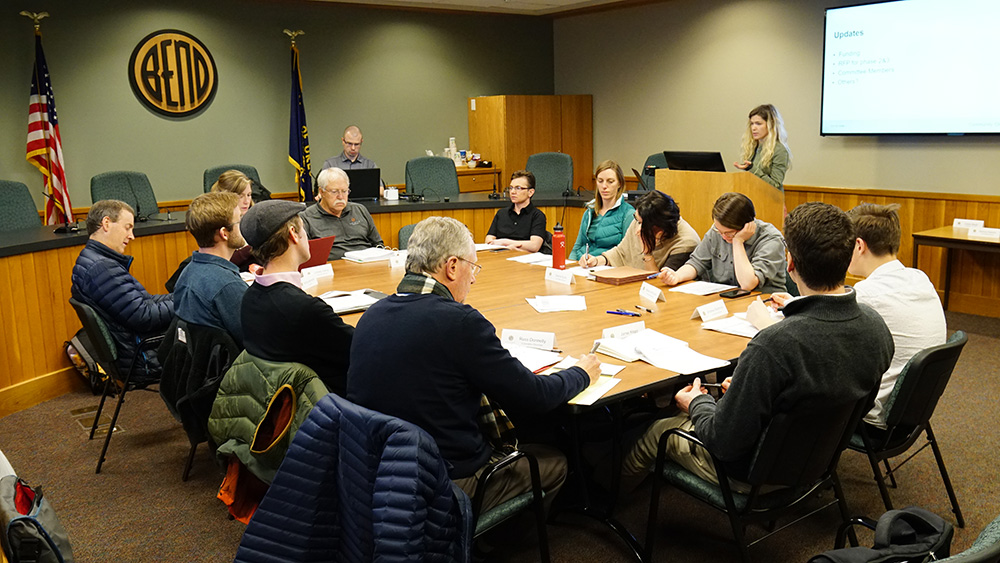 Diverse group of people sitting around a large table working.