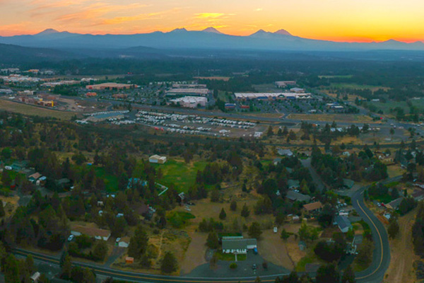 The City of Bend from overhead at sunset. Three Sisters mountains are in the background.