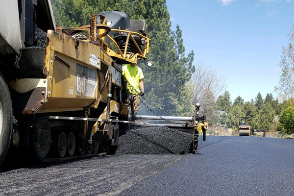 Machine paving a street.