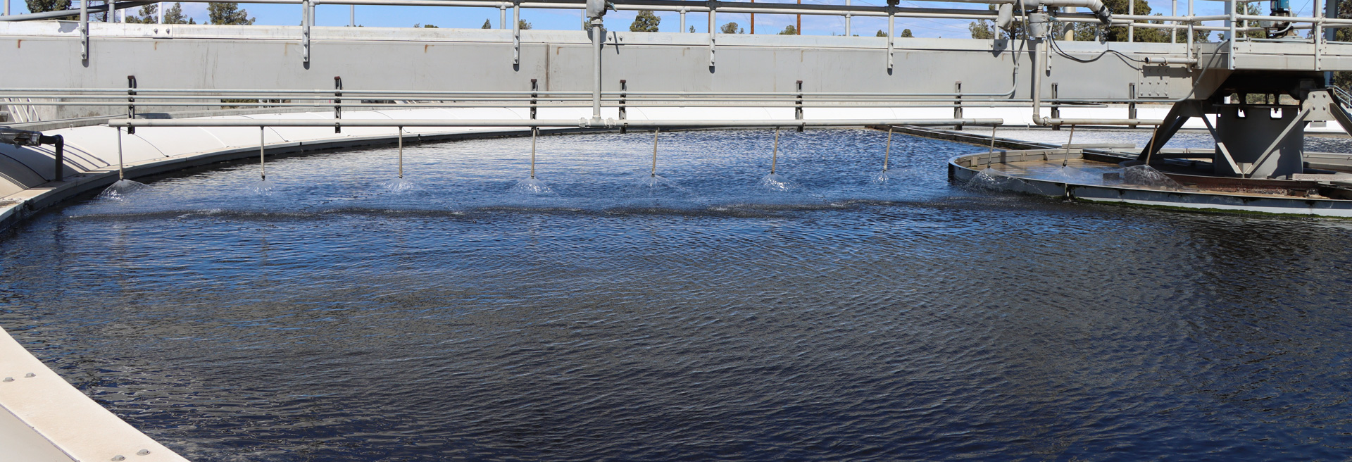 Wastewater cleaning pond. Equipment in the middle that treats the water. Catwalks surround the pond.