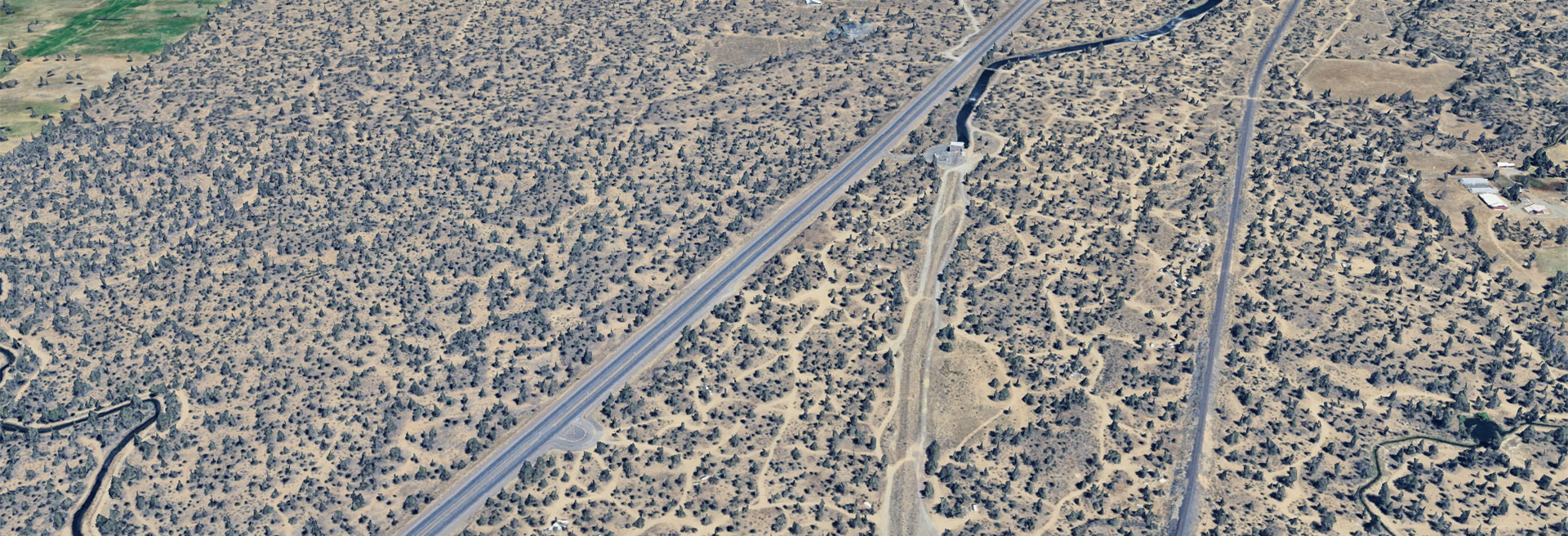 Satellite view of the area, roads, trees, a canal, a highway. 