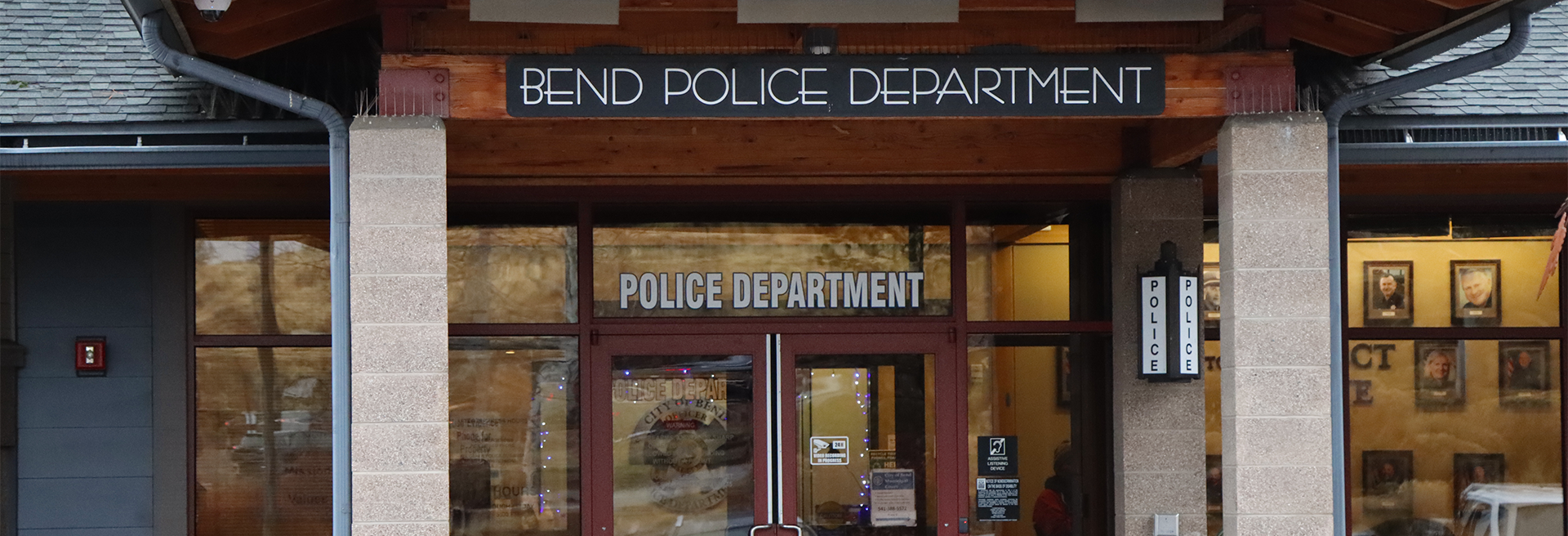 Front of the Police Department. Sign with the name, glass doors, concrete columns.