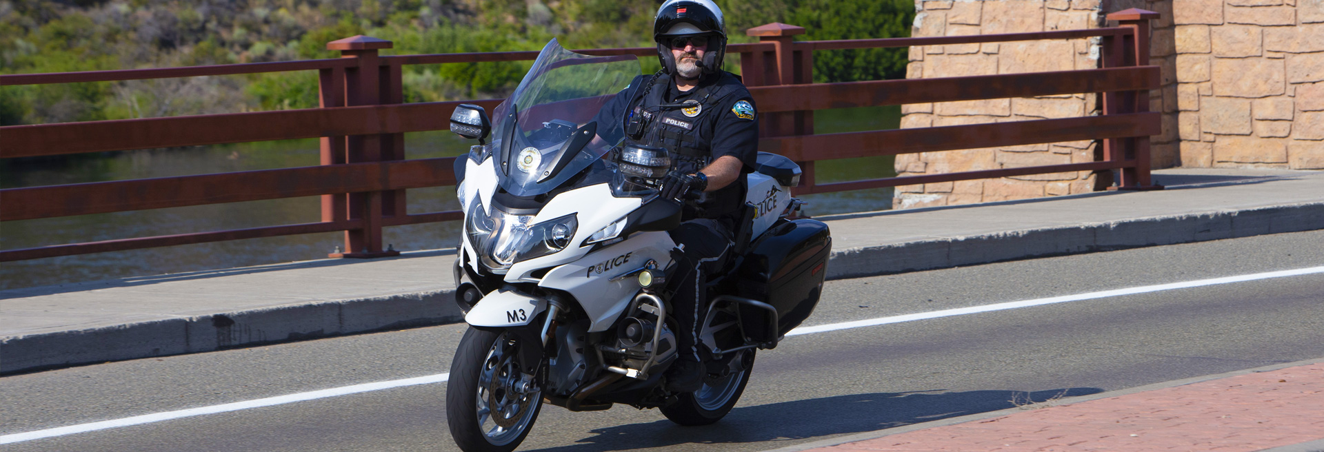 Police officer riding a motorcycle on a city street.