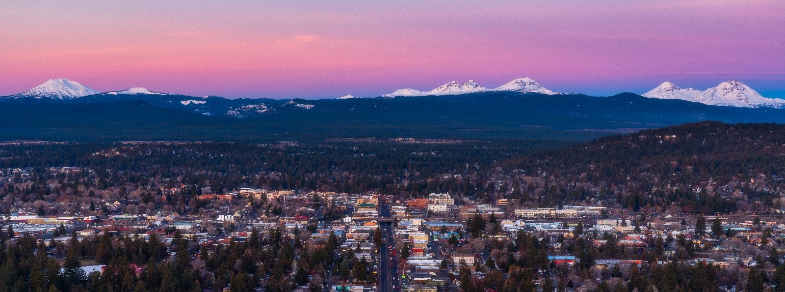 Sunrise over Bend's Core Area. Snow covered mountains in the background.