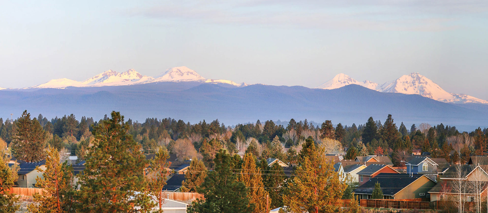 Southeast Bend neighborhood with the Three Sisters in the background at dawn.